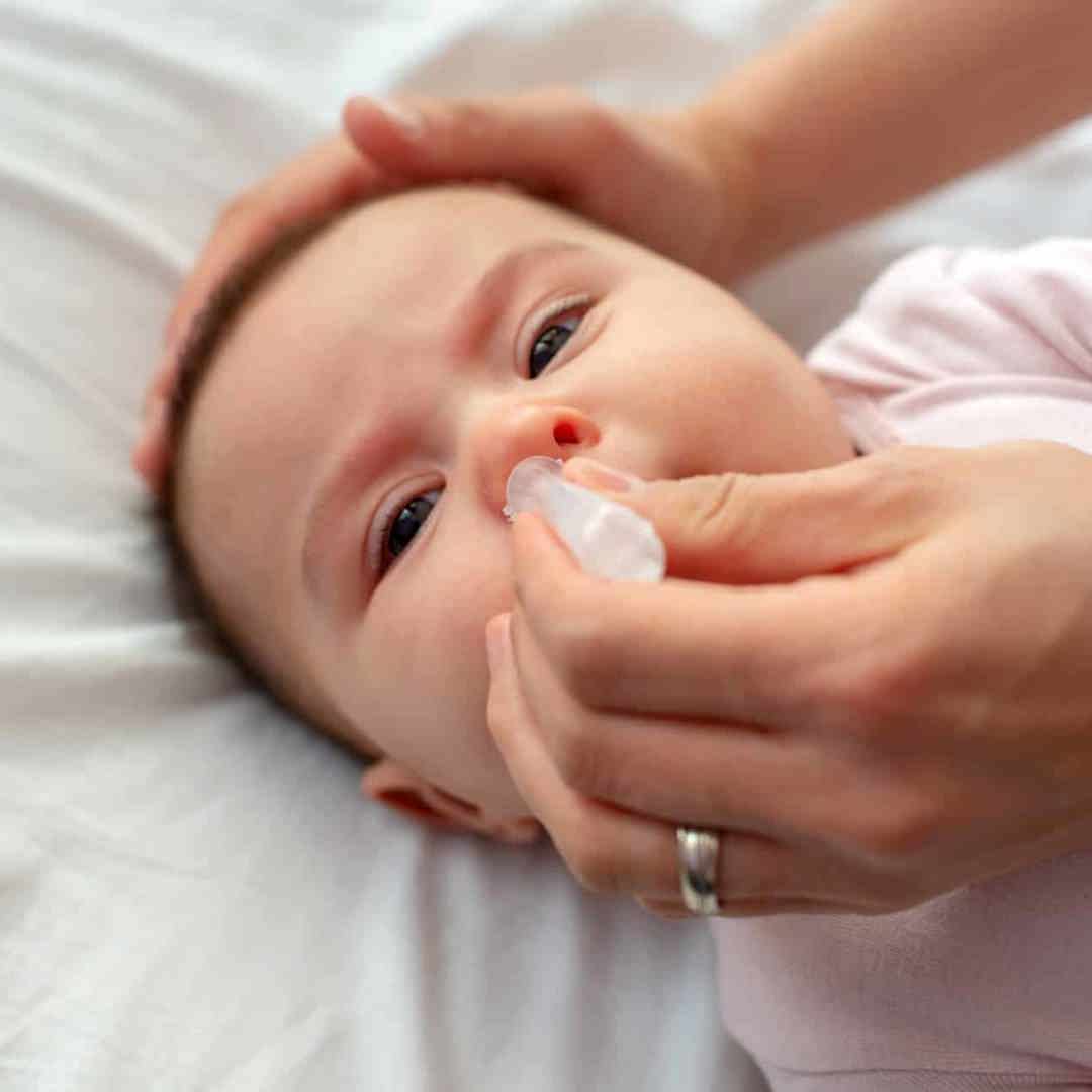 Baby met verkoudheid krijgt druppels in neus