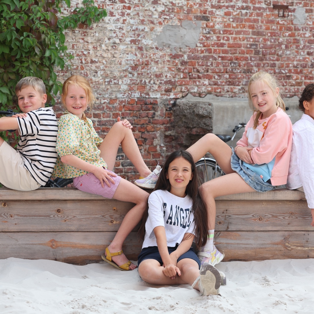 Vijf kinderen zitten buiten en geven tips over hoe praten met je kinderen 