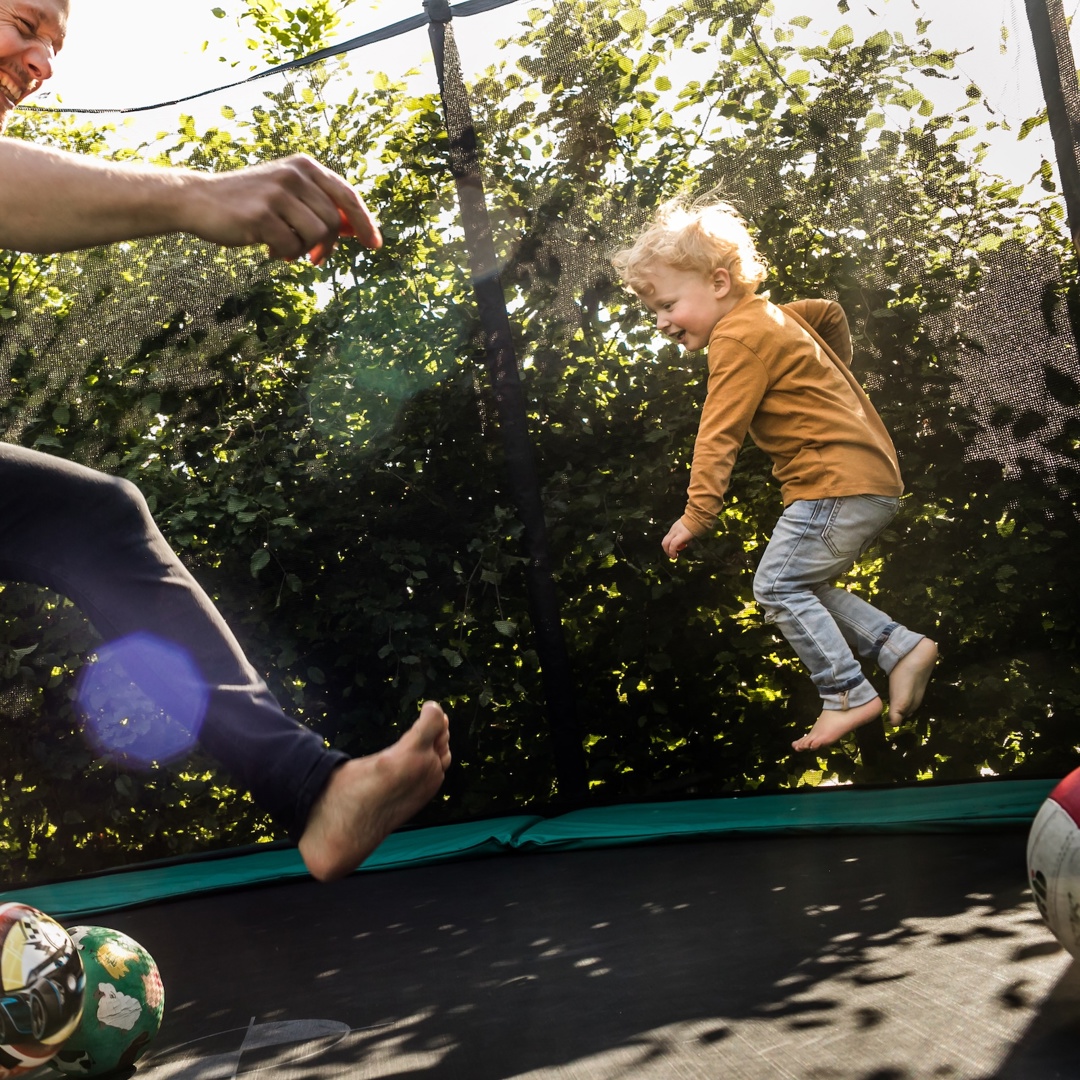Vader en zoon op trampoline hebben jongens andere opvoeding nodig dan meisjes