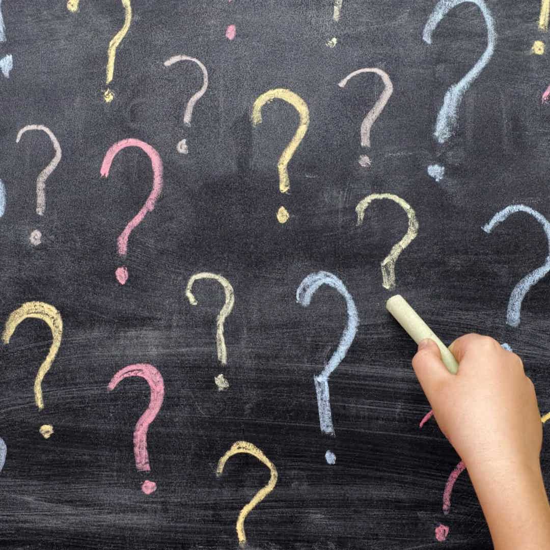 Kinderhand tekent vraagteken op bord: waarom vragen kleuter